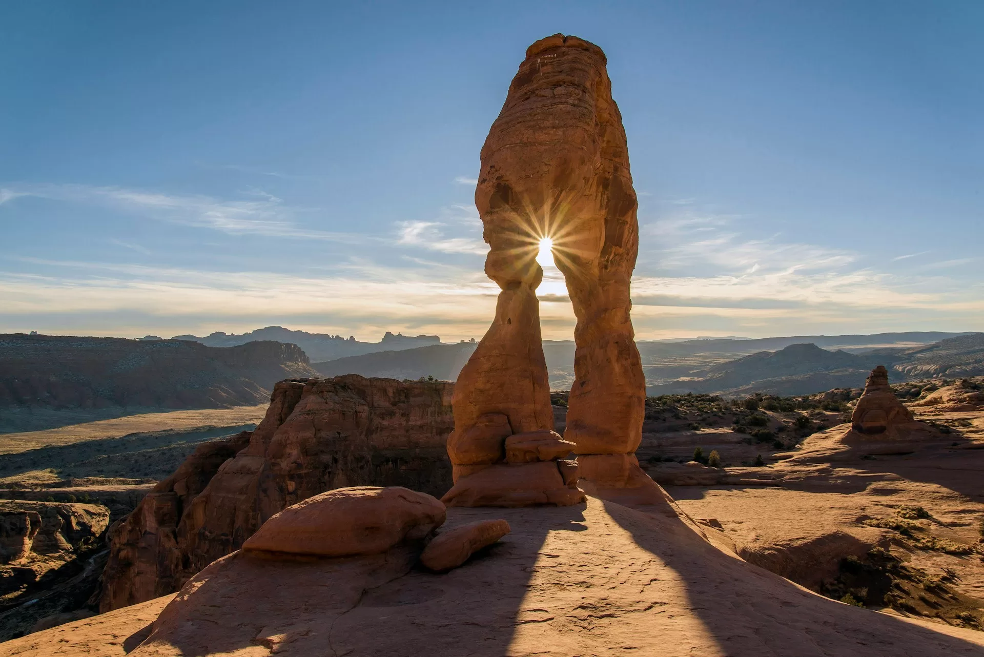 De Delicate Arch in Arches National Park, Moab met de ondergaande zon op de achtergrond