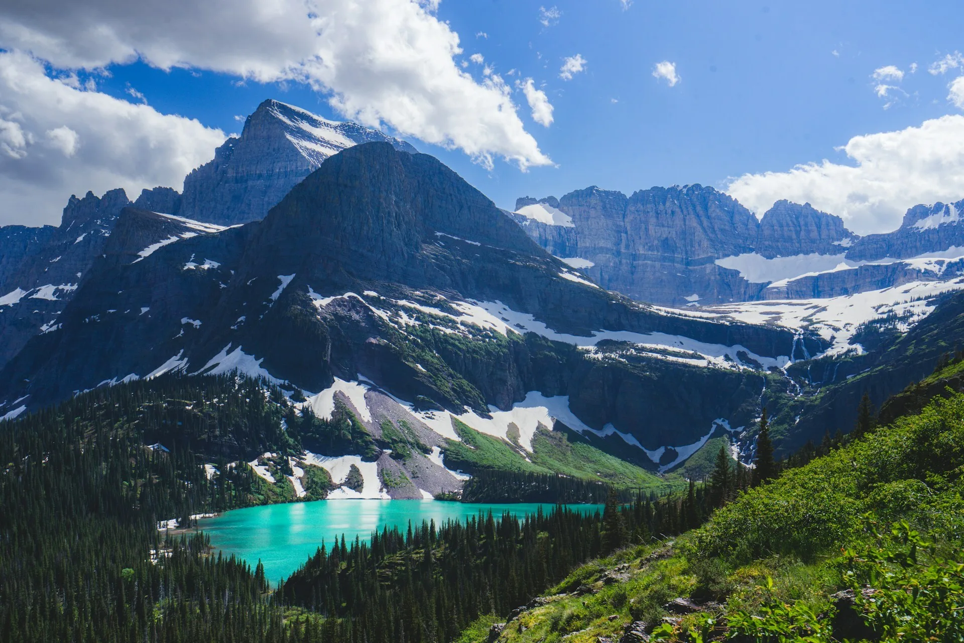 Helder blauw meer tussen de besneeuwde bergen in Glacier National Park