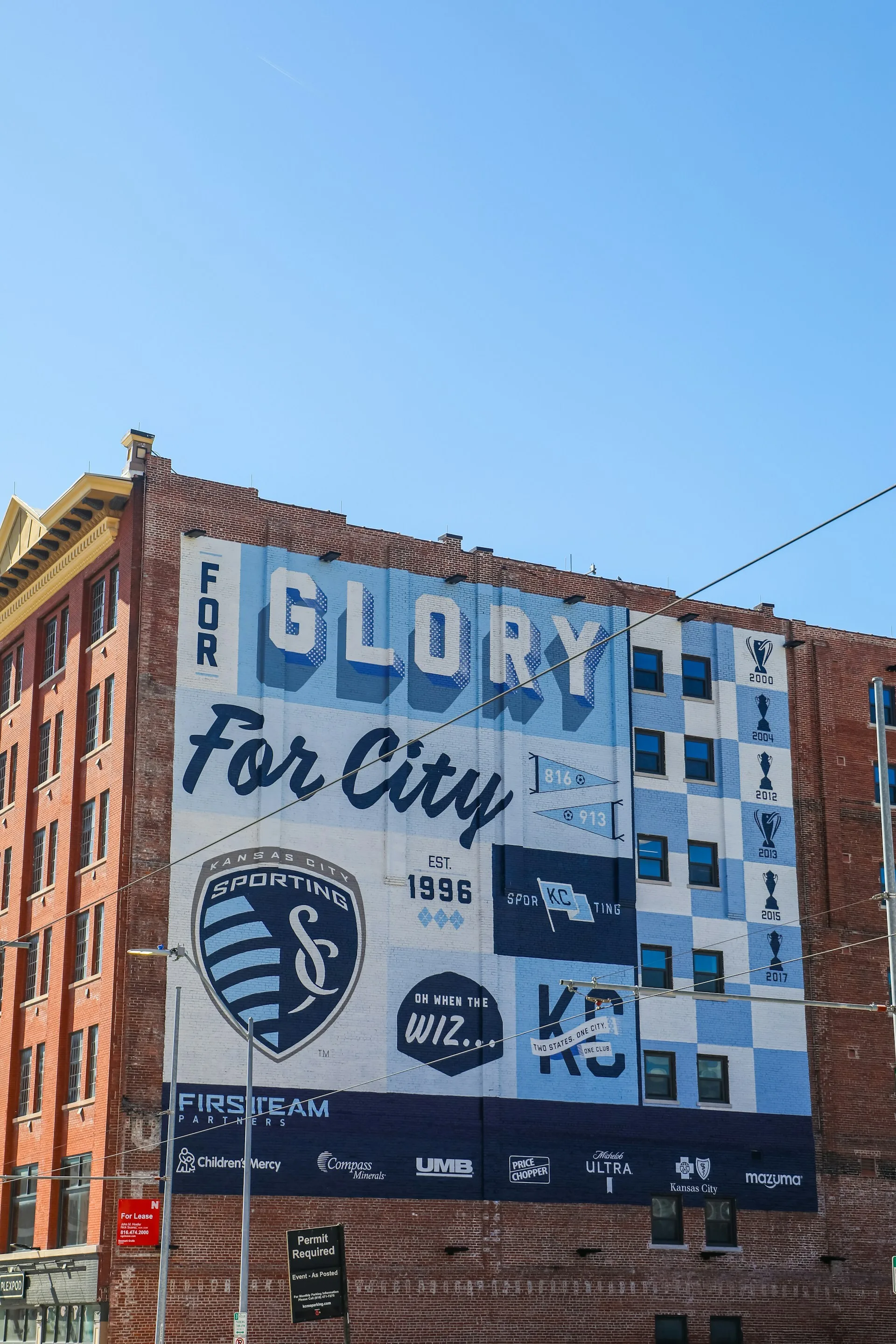 grote poster op de zijkant van een gebouw waar op staat: ''for glory for city'' van het Kansas city sporting