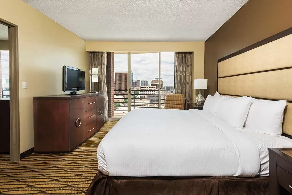 Standaardkamer met apart woonkamergedeelte en een balkon in het Hotel Double Tree Suites Austin