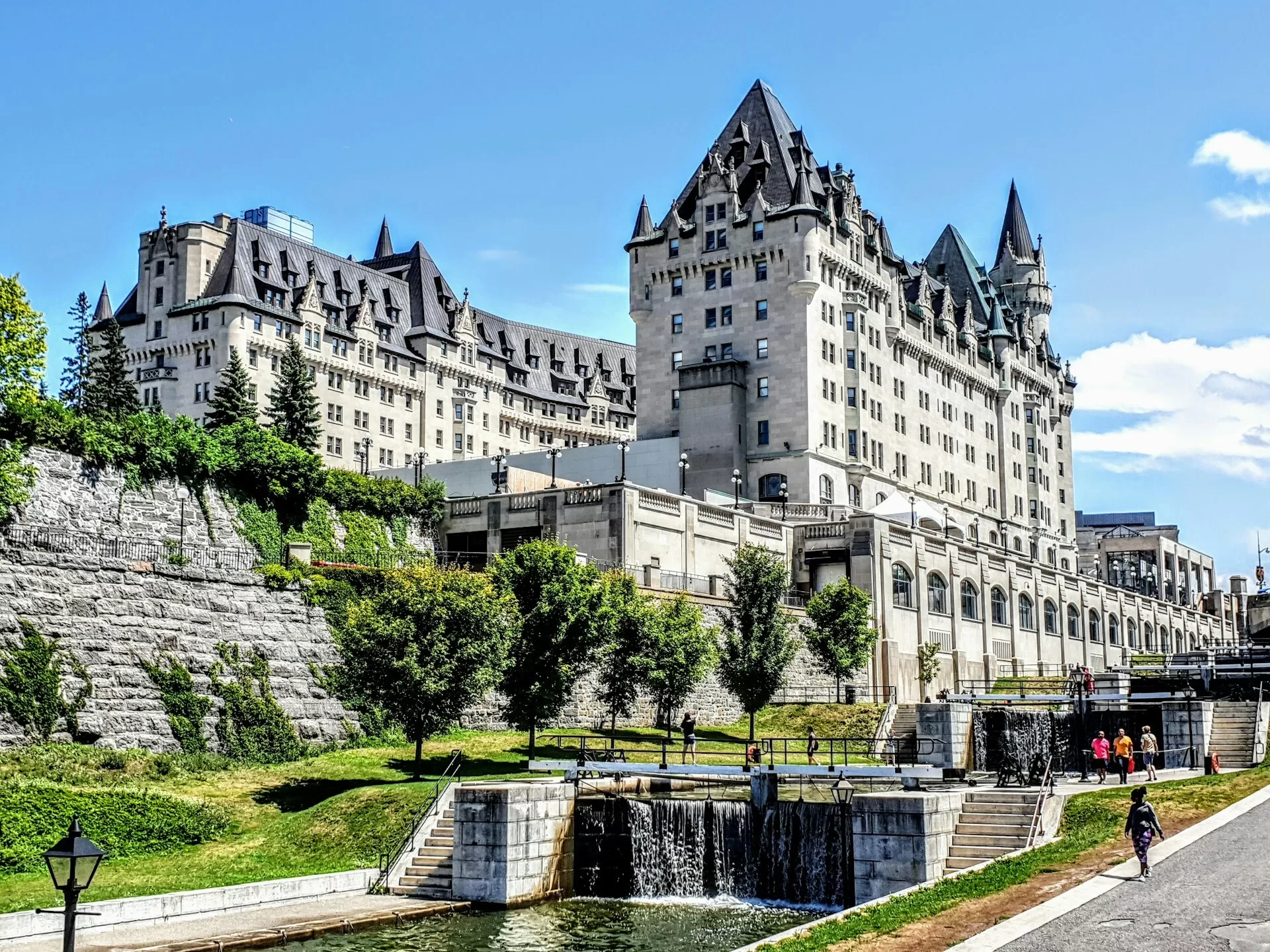 Fairmont Chateau Laurier met water op de voorgrond op een zonnige dag, iconisch hotel in Ottawa