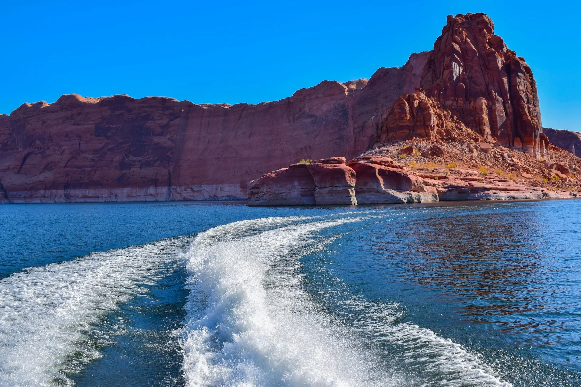 Zicht vanuit een bootje over Lake Powell en de red rocks