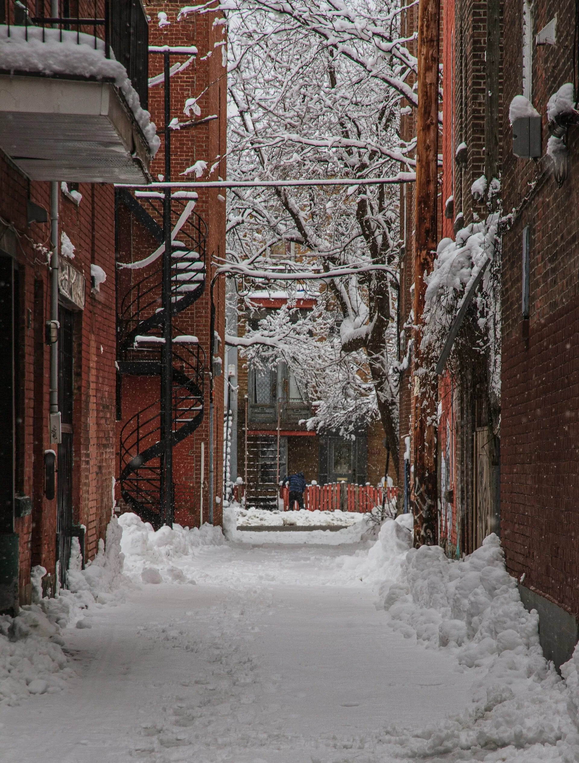 Sneeuw in een smalle steeg met rode gebouwen in Montreal