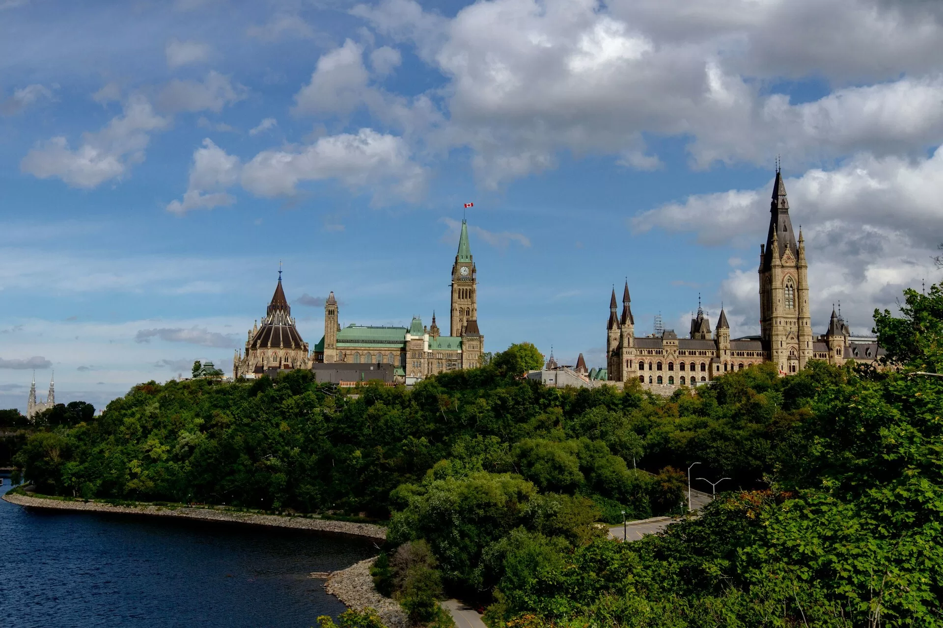 De oever van de Ottawa River met o.a. de Peace Tower en Government Building achter de bomen