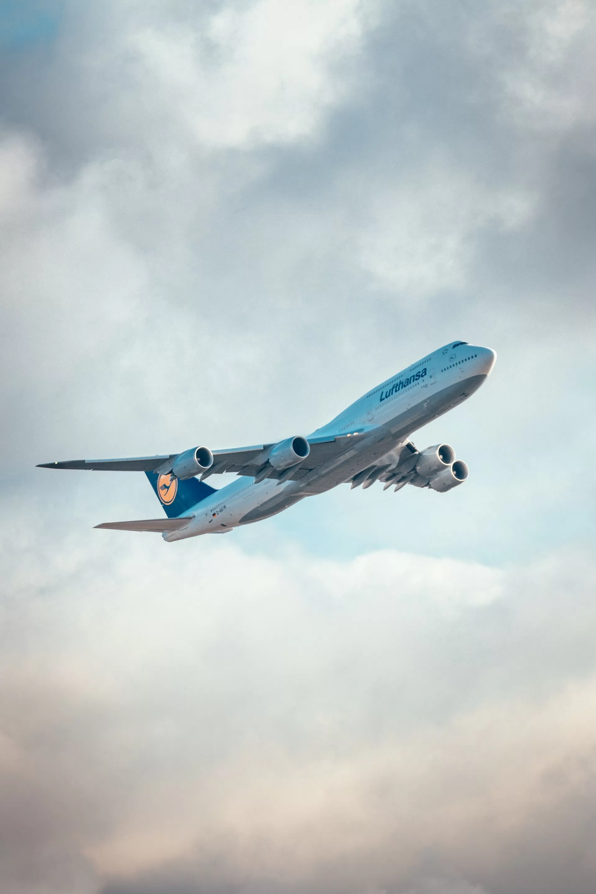 Lufthansa 747 net opgestegen met de lucht en wolken op de achtergrond