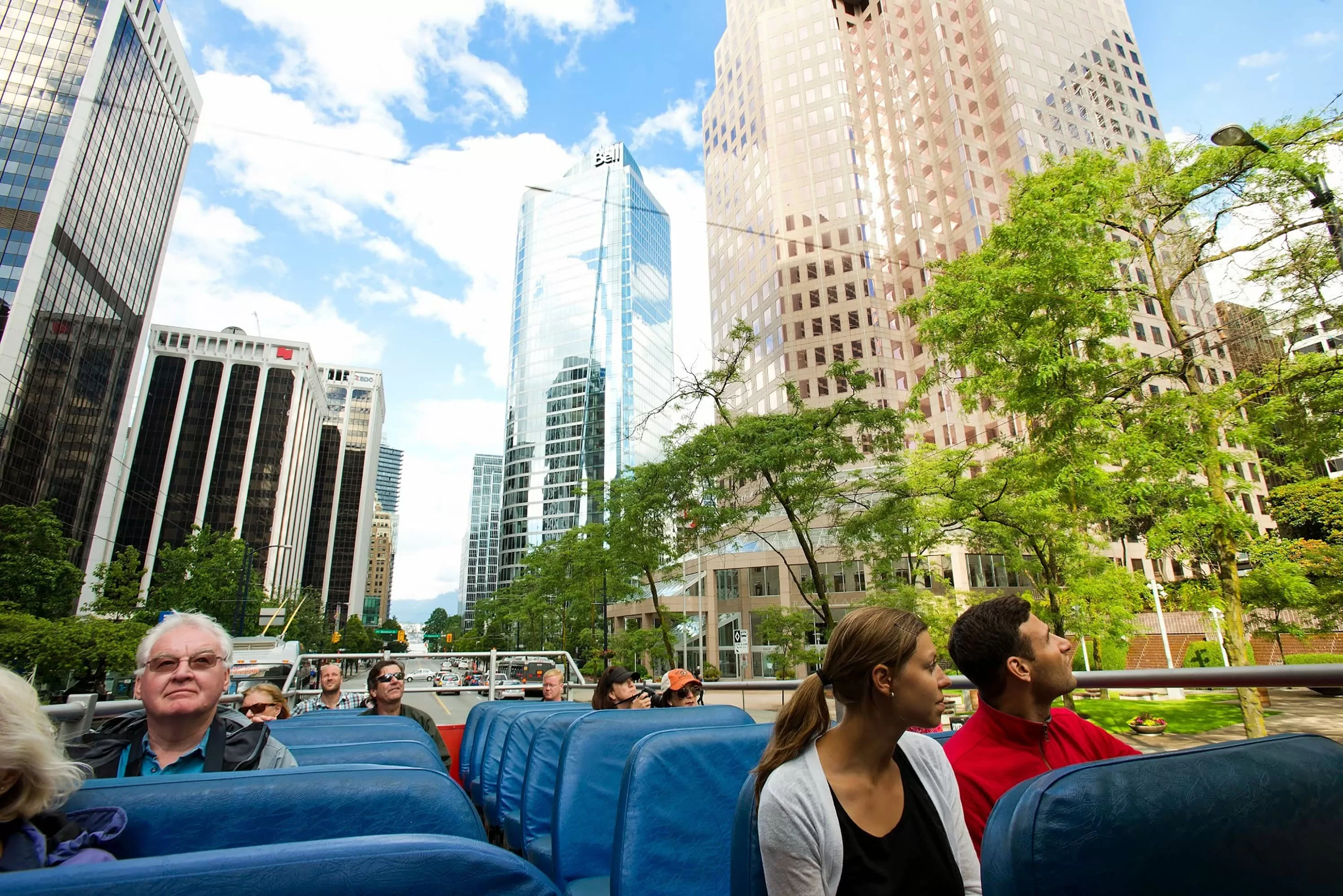 Hop-on-Hop-off-Bustour in Vancouver mit Touristen, die die Sehenswürdigkeiten in einem offenen Doppeldeckerbus erkunden