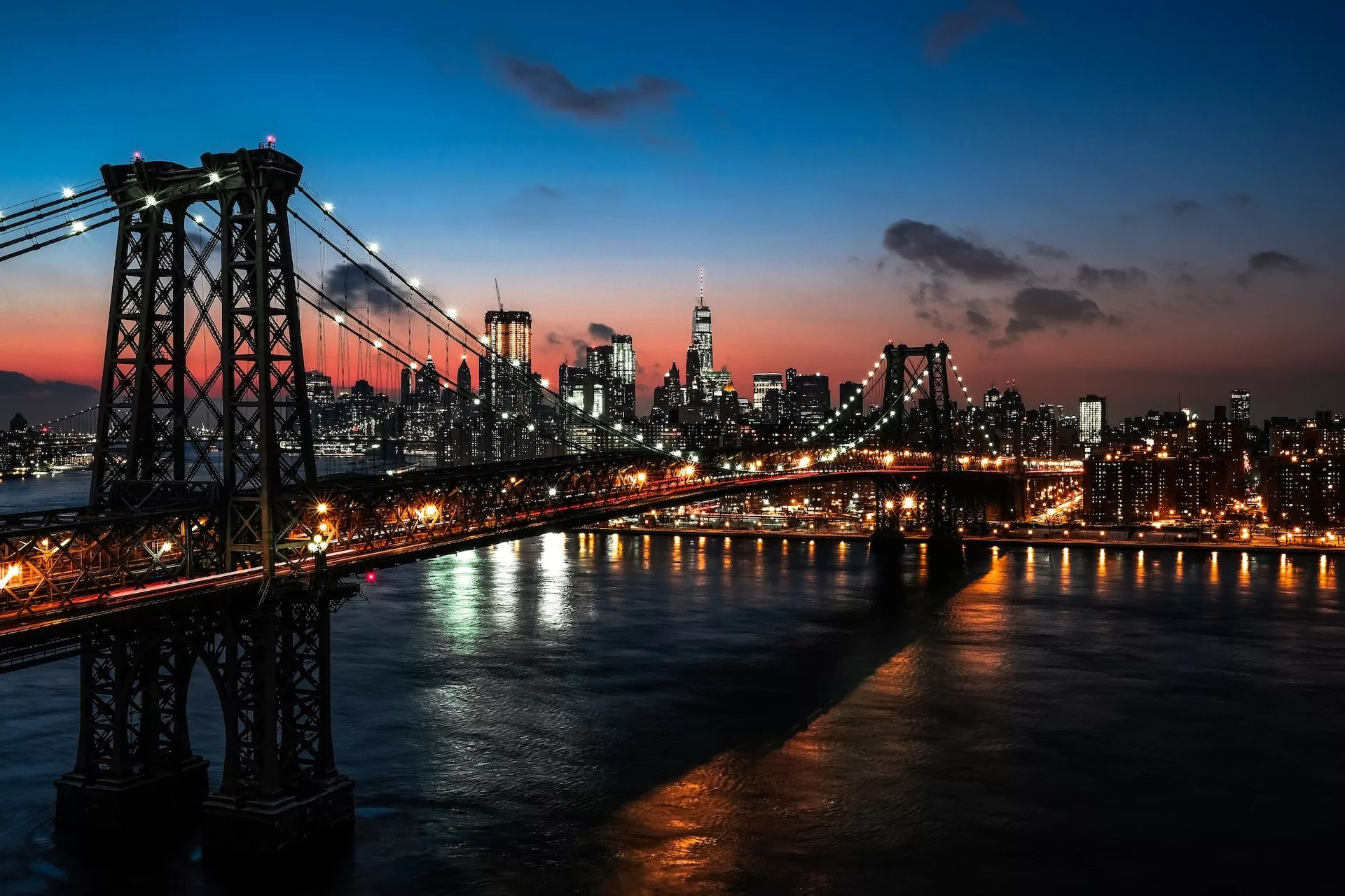 De verlichte Williamsburg Bridge over de East River in Manhattan New York