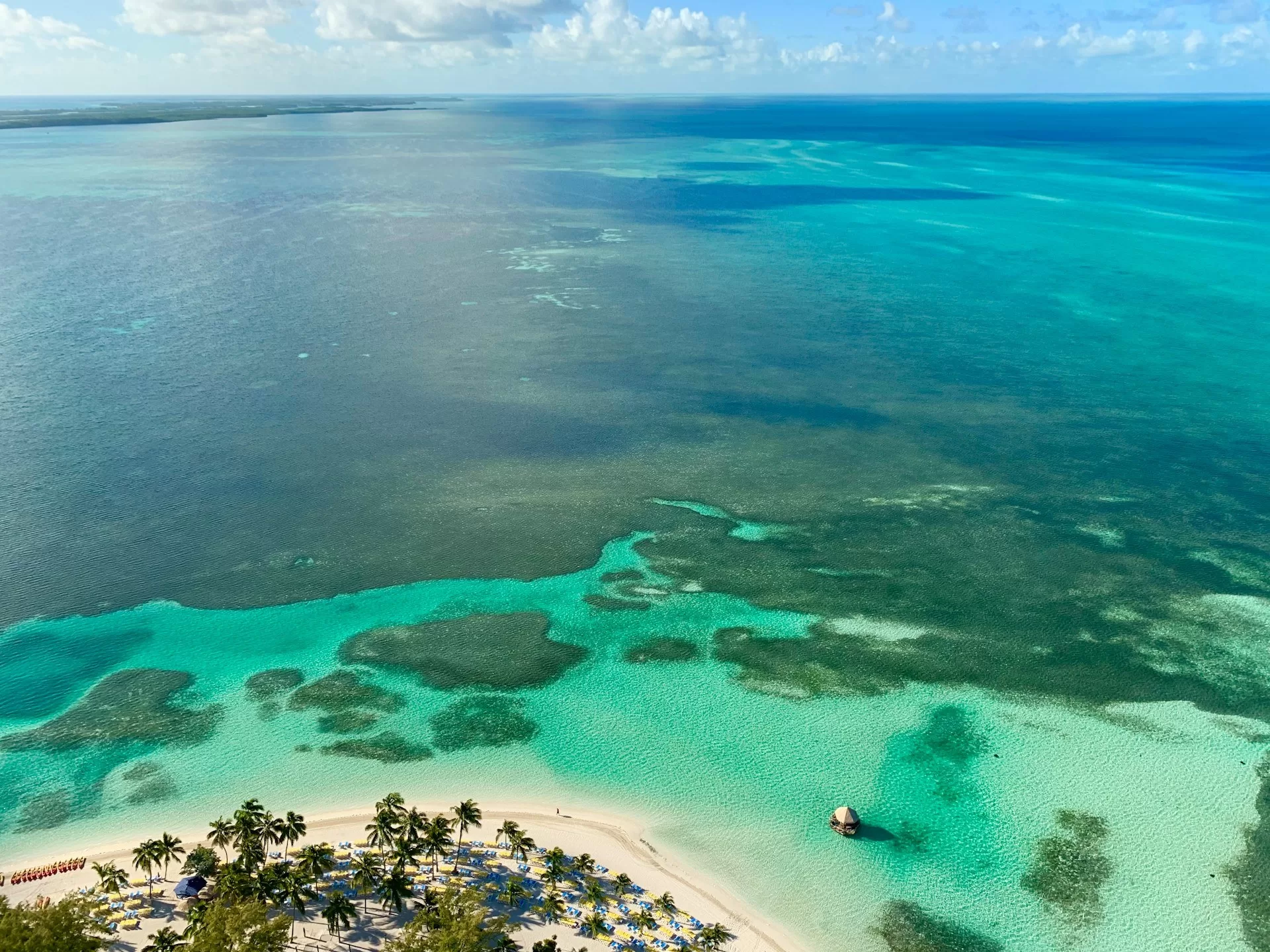 Het strand van Coco Cay met de helderblauwe zee van de Bahama's van bovenaf