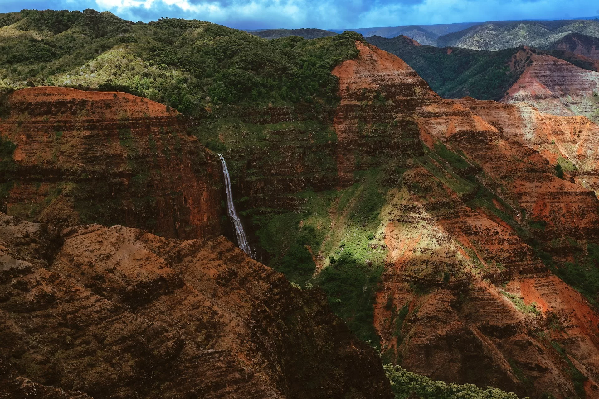 Luchtfoto van Waimea Canyon op Kauai, Hawaï, met groene en bruine kloven en berglandschappen