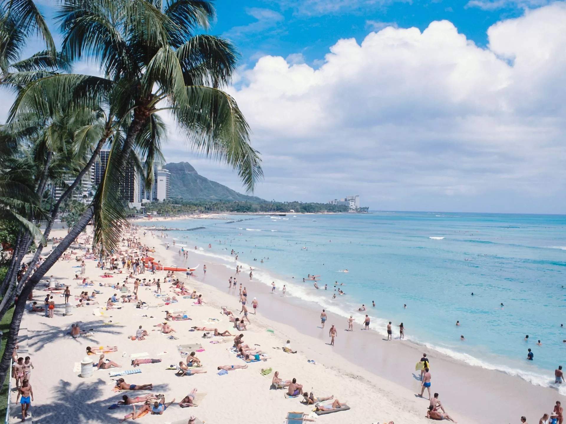 Mensen liggend in de zon op Waikiki Beach, Oahu met op de achtergrond Diamond Head