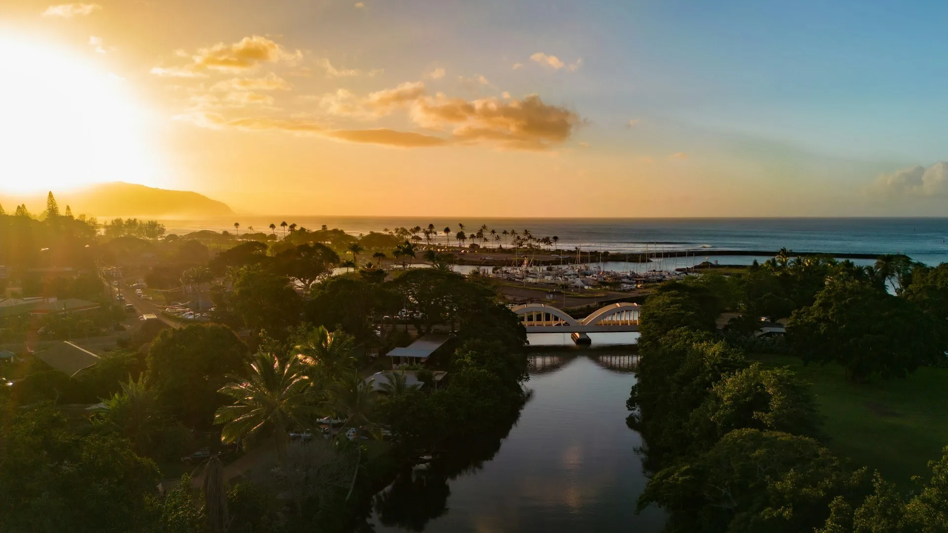 Luchtfoto van Oahu North Shore bij Haleiwa, Hawaii tijdens golden hour, met zicht op de brug en oceaan