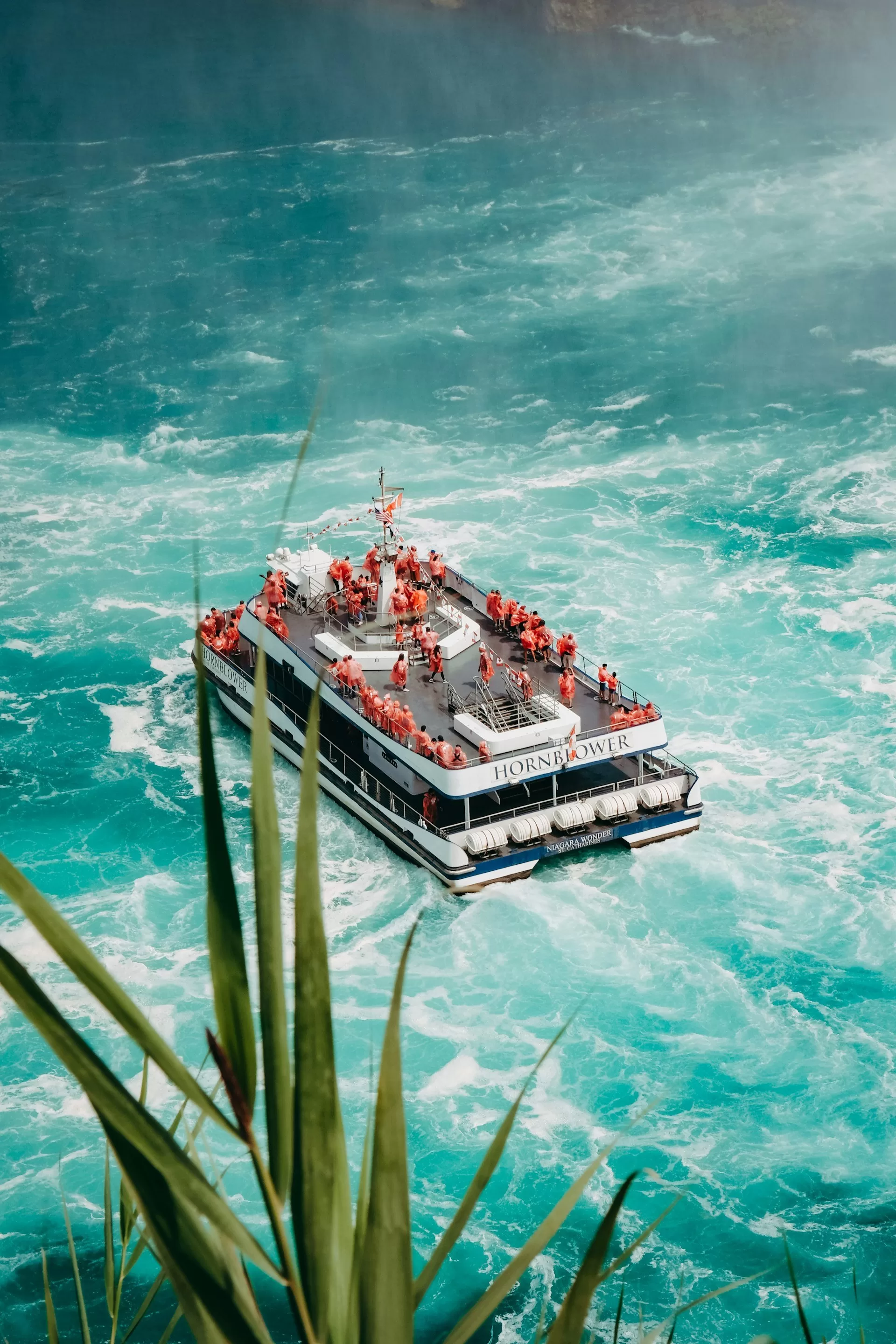 De hornblower met een dek vol toeristen onder de Niagara Falls in Canada