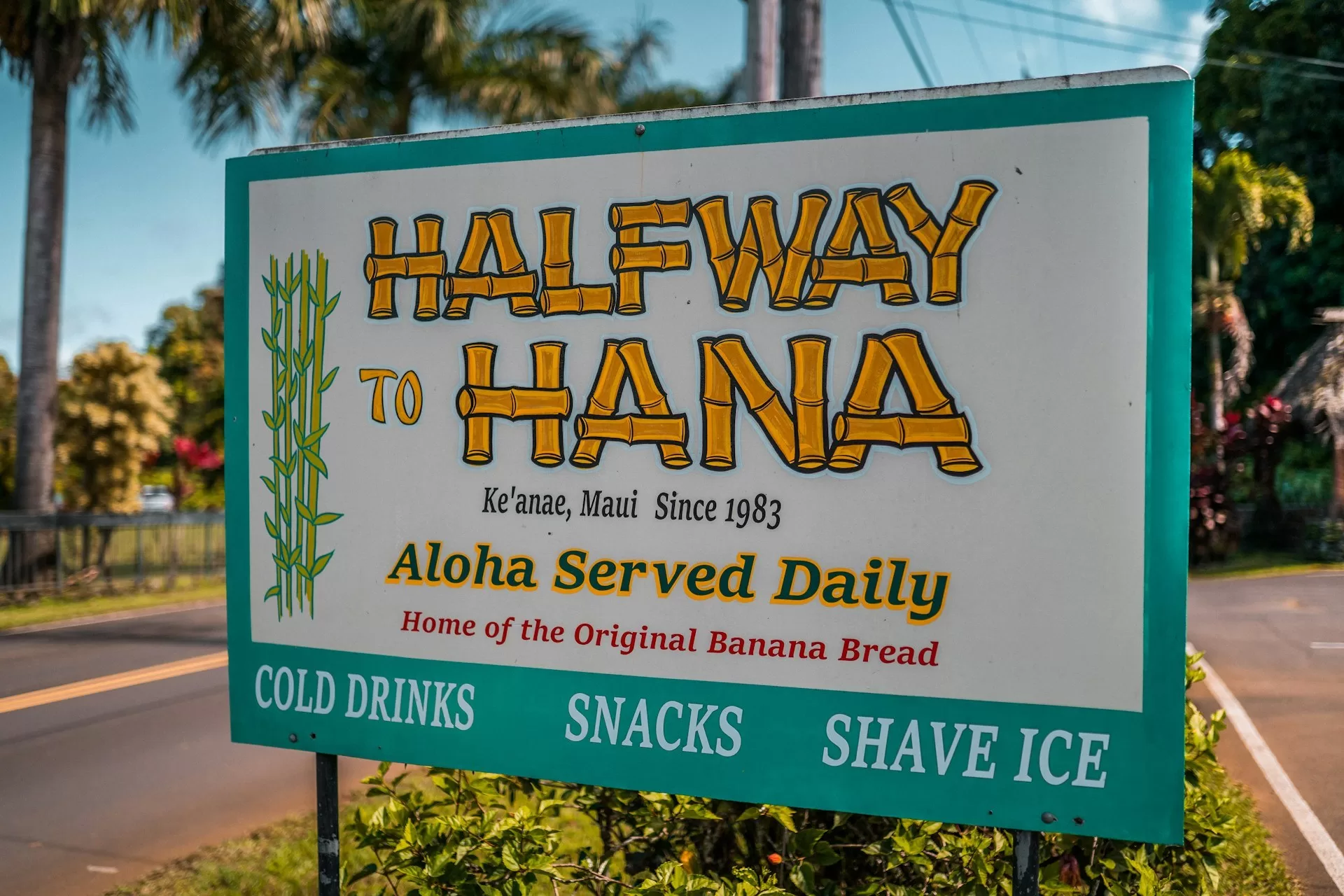Lichtblauw bord met "Halfway Hana" op de Road to Hana in Maui, Hawaï