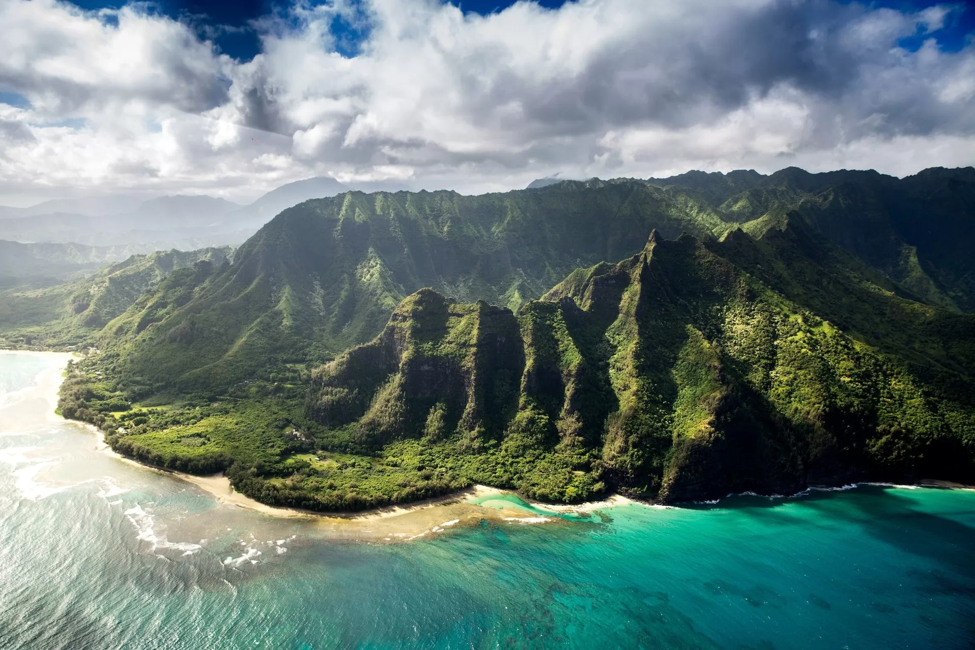 Luchtfoto van de turquoise oceaan en groene kustlijn van Kauai