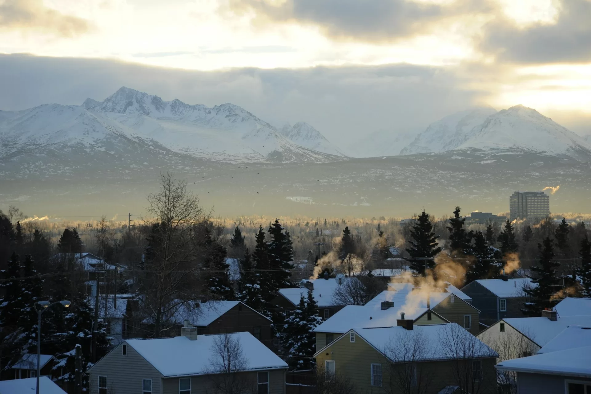 Huizen met besneeuwde daken in Anchorage met de Chugach bergen op de achtergrond