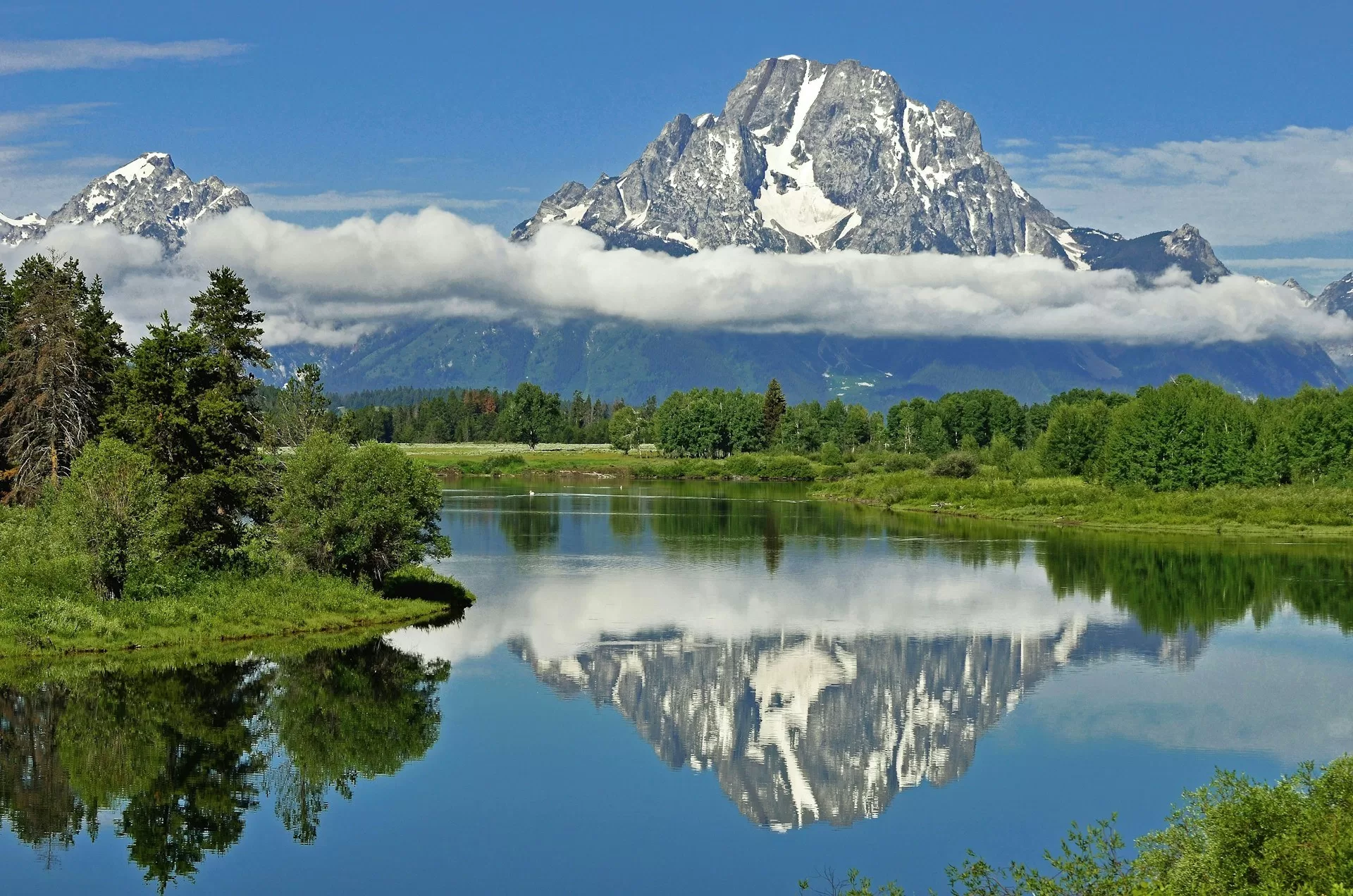 Een besneeuwde Mount Moran voor een meer in Grand Teton National Park