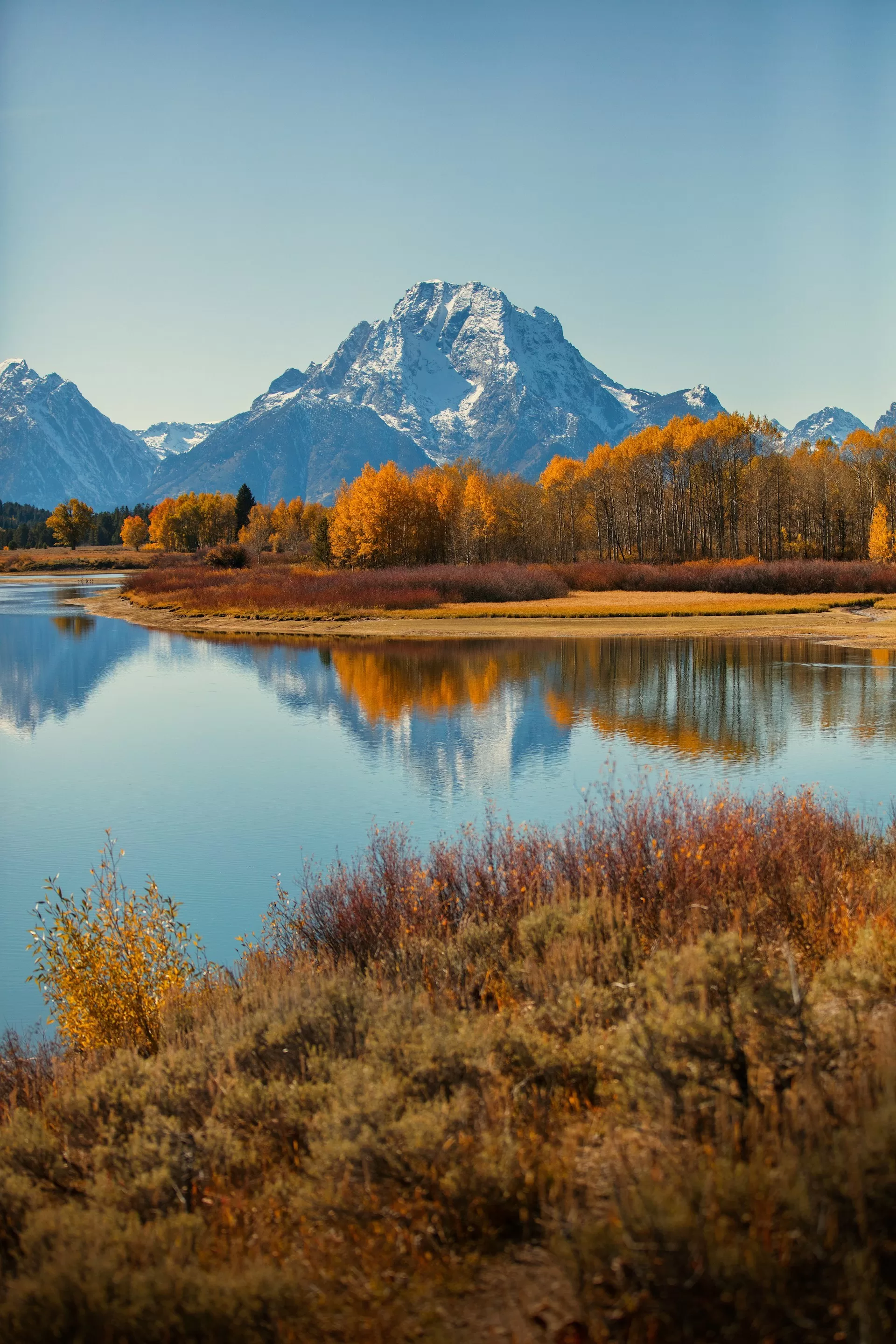 Een meer met besneeuwde bergen op de achtergrond in Grand Teton National Park