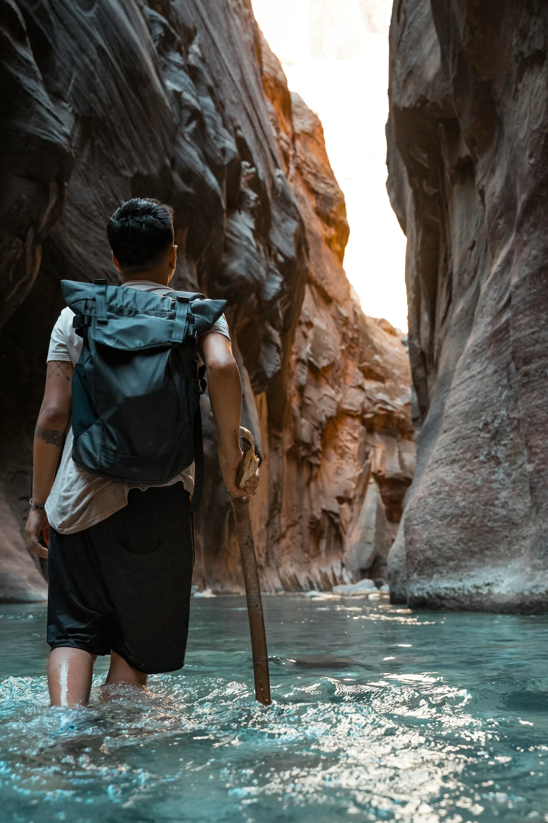 Wandelaar lopend in het water in The Narrows van Zion National Park