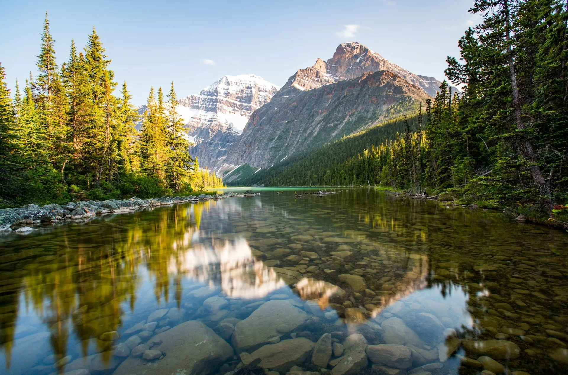 Het stille kristalheldere water van Lake Edith met de bergtoppen van Jasper National Park op de achtergrond.