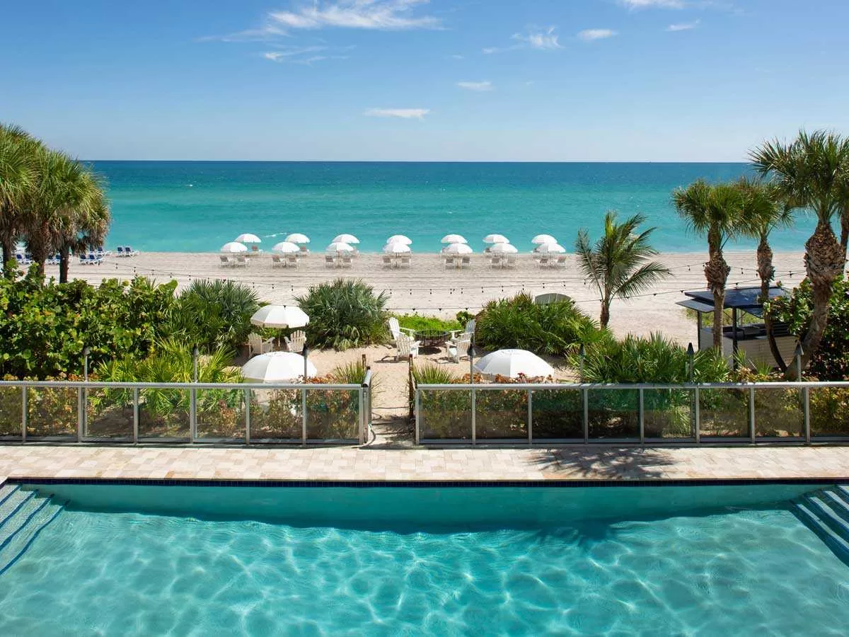 Het zwembad van het Sole hotel in Miami met een pad dat leidt naar het strand