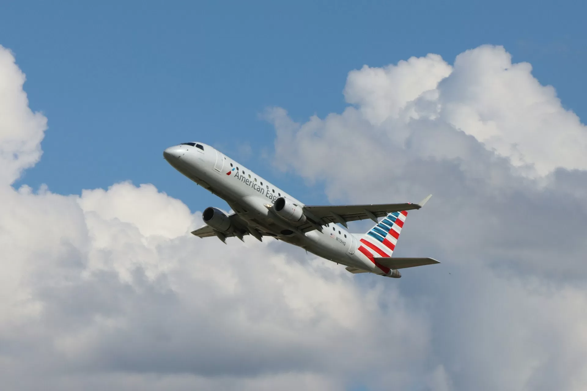 American Airlines-vliegtuig stijgt op met blauwe lucht en wolken op de achtergrond