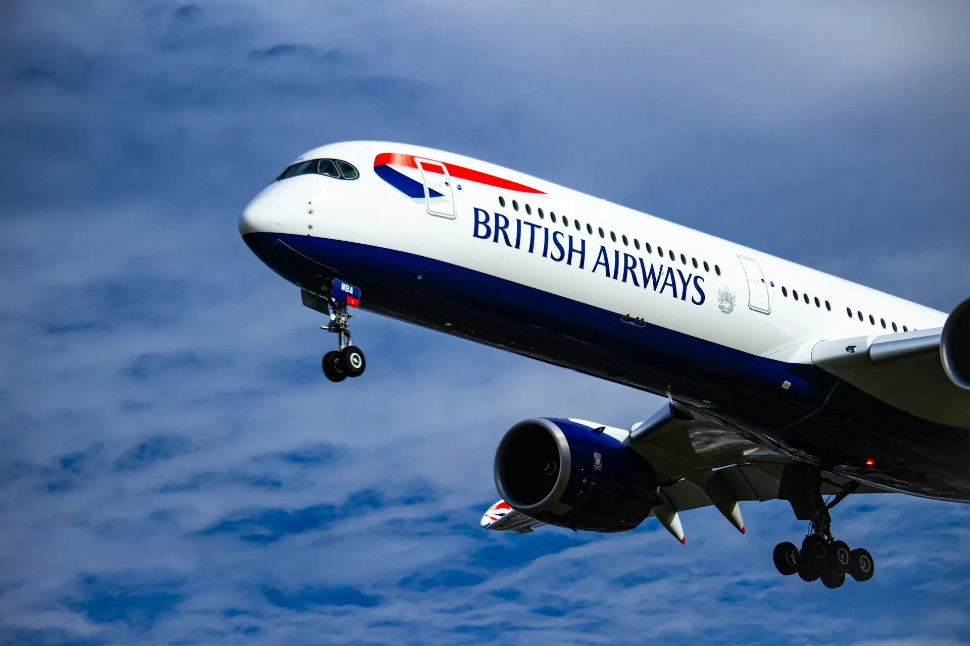 De voorkant van een British Airways-vliegtuig, met de wielen uit en de focus op het vliegtuig zelf