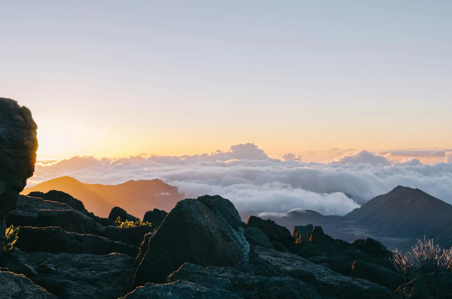 Uitzicht over de zonsopkomst tussen de wolken vanaf de bergen van Haleakala National Park op Maui