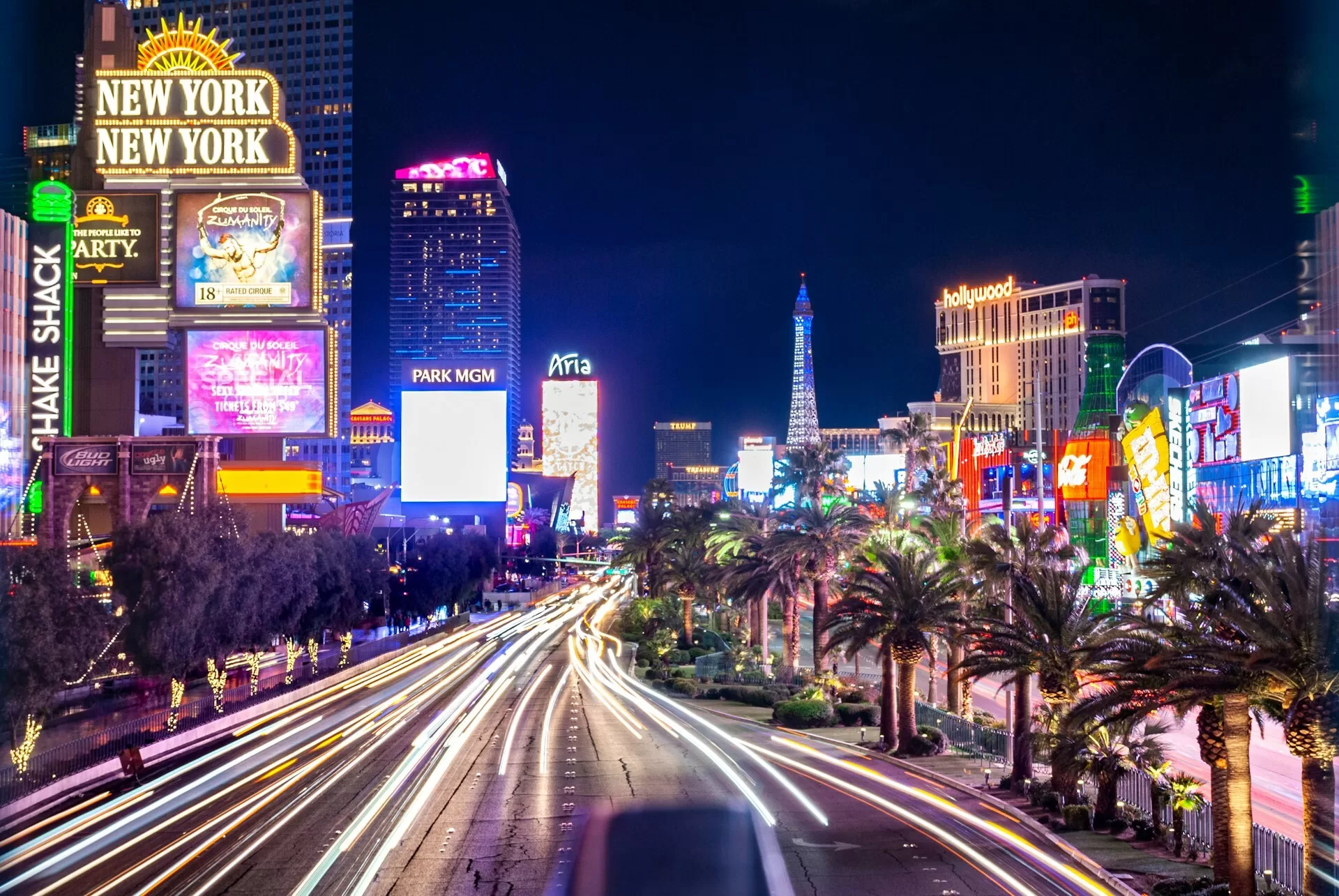 De Las Vegas Strip bij nacht met palmen en verlichte hotels