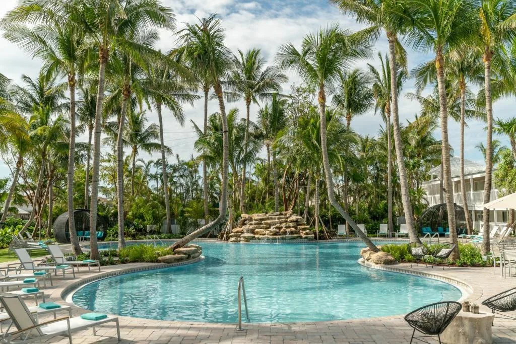 Ligbedden tussen de palmbomen aan het buitenzwembad bij het Hotel Havana Cabana